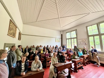 Rollenwechsel - die Schulteams und ihr Verantwortlichen nehmen auf historischen Schlbänken Platz.JPG