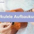 Ukulele Aufbaukurs für alle Nahaufnahme einer Person, die auf einer Holzukulele spielt, mit Schriftzug Ukulele Aufbaukurs.
