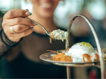 Gericht auf einem kreativ angerichteten Teller Eine lächelnde Person genießt ein vorzügliches Gericht auf einem kunstvoll gestalteten Teller.A smiling person enjoys an exquisite dish on an artistically designed plate.
