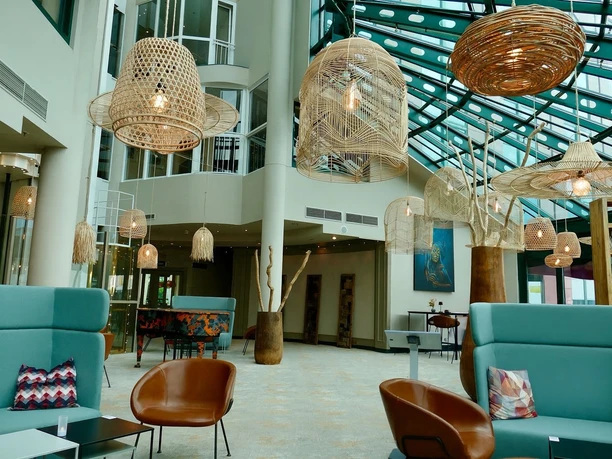 Hotel Amadeus Frankfurt Heller, verglaster Eingangsbereich mit Sitzgelegenheiten.