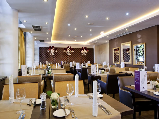 Mercure Hotel & Residenz Frankfurt Messe - Restaurant Restaurant mit eingedeckten Tischen in modernem Ambiente.