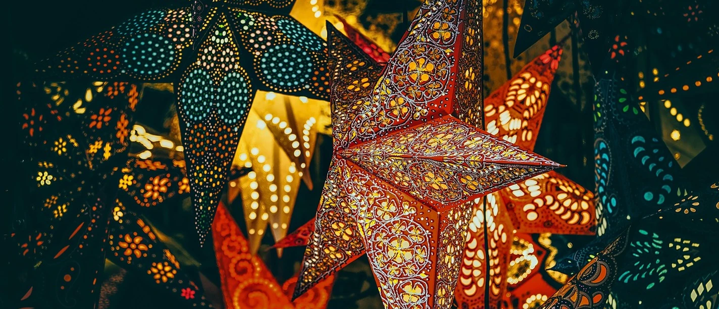 Leuchtende Sternlaternen an Weihnachten Leuchtende, kunstvoll verzierte Sternlaternen mit filigranen Musterungen in warmen Farbtönen.