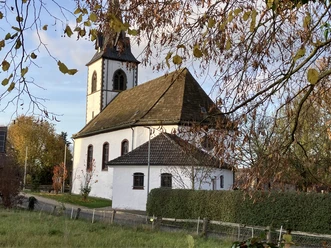 Die Katholische Kirche in Tietelsen, umgeben von Bäumen und Hecken.