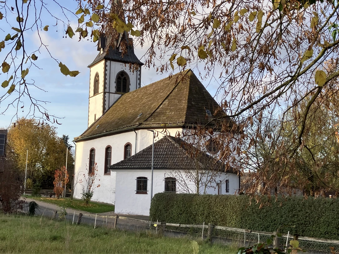 Die Katholische Kirche in Tietelsen, umgeben von Bäumen und Hecken.
