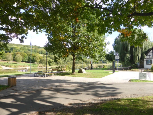 Der Dampferanleger befindet sich an der Weserpromenade in Wehrden, wo es Sitzmöglichkeiten unter Bäumen gibt.