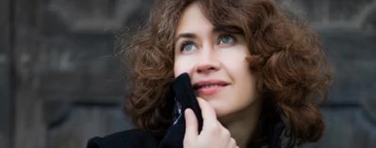 Weltklassik am Klavier: Anna Zassimova Zu sehen ist die Künstlerin Anna Zassimova im Porträt. Dunkle, schulterlange und gelockte Haare.