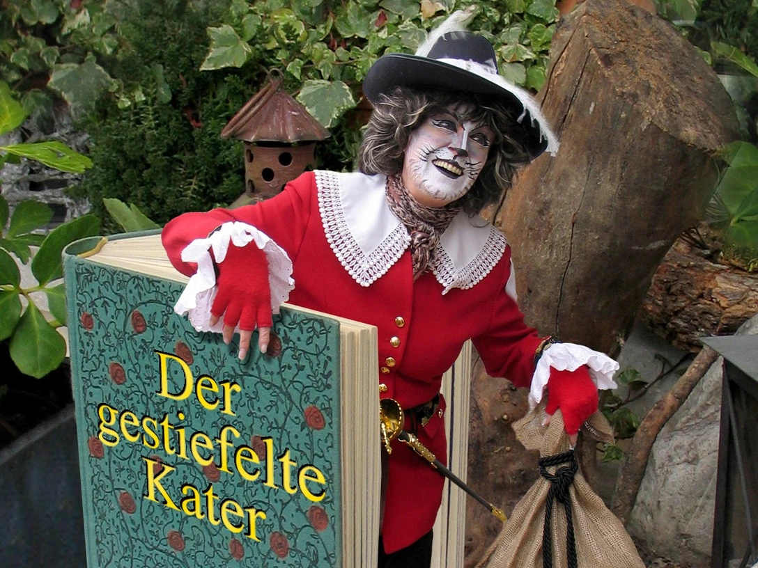Eine Frau als Katze verkleidet kommt aus dem Buch "Der gestiefelte Kater" gestiegen.