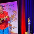 Wolfgang Hering Ein Mann spielt auf einer Ukulele und lächelt.