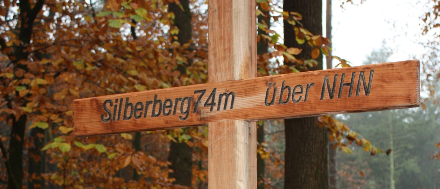 Wingst_Gipfelkreuz_Silberberg Gipfelkreuz aus Holz mit Gipfelbuch am Silberberg in der Wingst, umgeben von buntem Herbstwald.