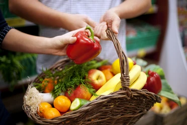 Korb gefüllt mit gesundem Gemüse und Obst