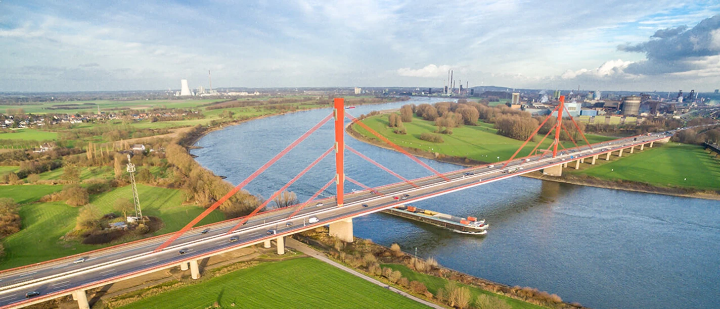 bruecke-niederrhein-sommer.jpg Luftaufnahme der Rheinbrücke Neuenkamp in Duisburg über den Fluss und umliegende Felder.