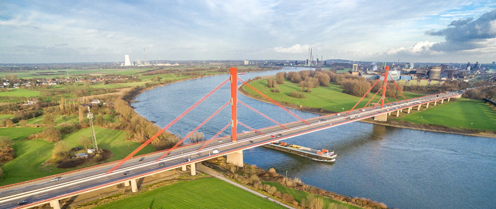 bruecke-niederrhein-sommer.jpg Luftaufnahme der Rheinbrücke Neuenkamp in Duisburg über den Fluss und umliegende Felder.