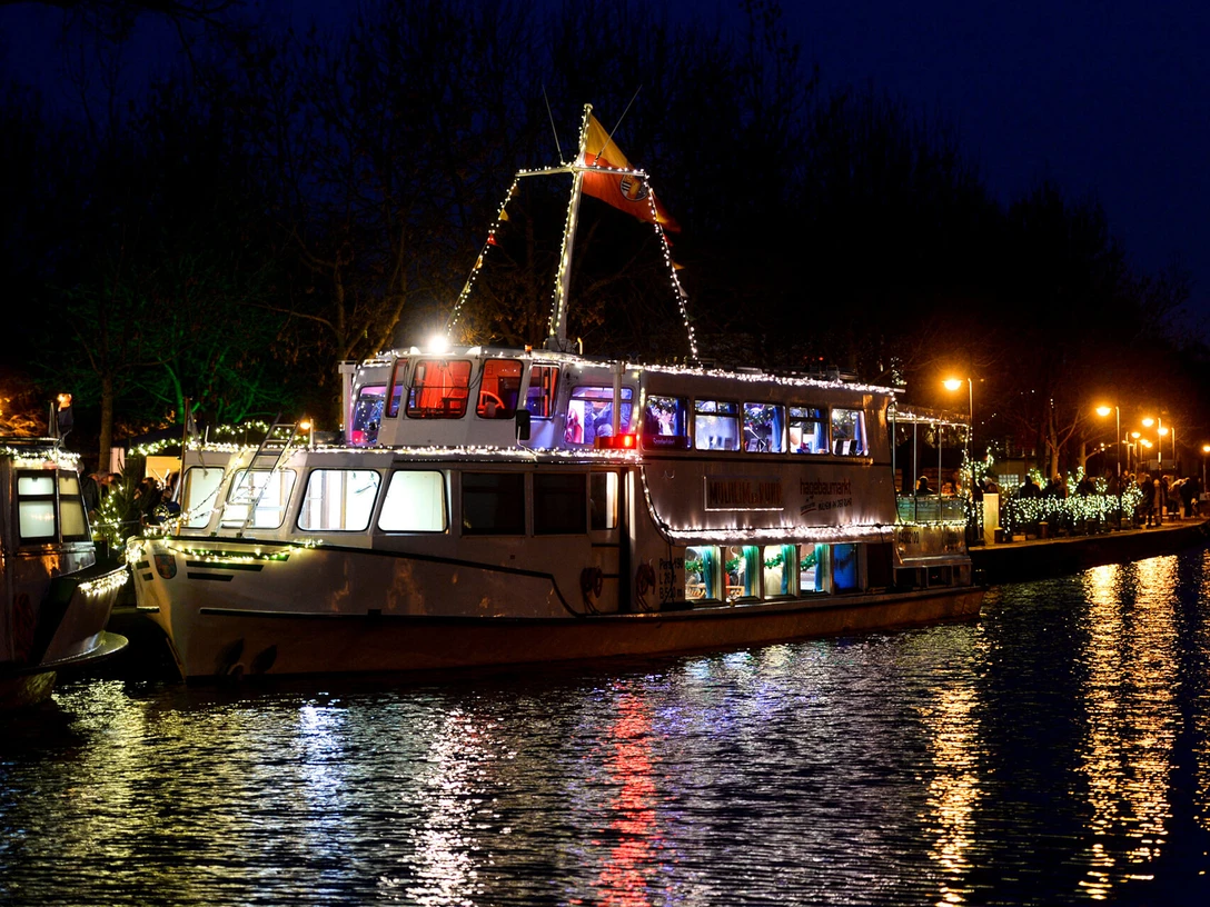 Weiße Flotte, Mülheim an der Ruhr Ein festlich beleuchtetes Ausflugsschiff gleitet bei Nacht über ein ruhiges Gewässer.