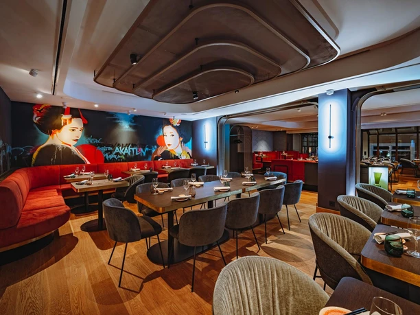 Modernes Restaurant Akaiten mit gedeckten Tischen, roten Sitzbänken und Geisha-Wandbild
