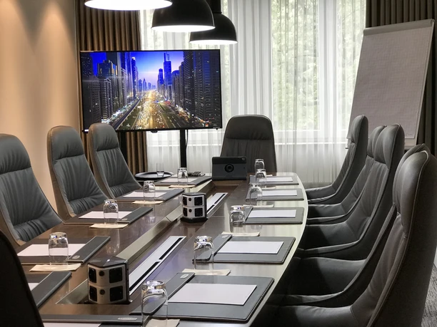 Mercure Hotel Kaiserhof Frankfurt City Center - Konferenzraum Konferenzraum mit Ledersesseln und großem Bildschirm.