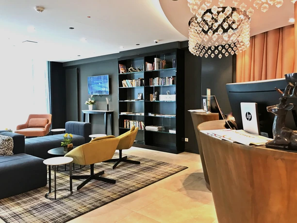 Mercure Hotel Kaiserhof Frankfurt City Center- Hotellobby Hotellobby mit Rezeption, Sitzecke und Bücherregal.