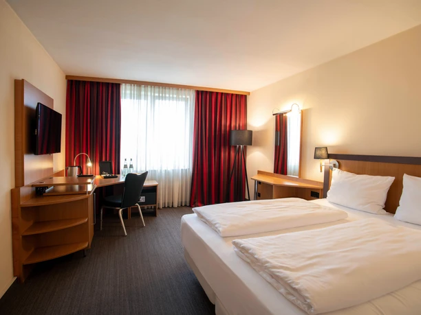 Best Western Mörfelden - Hotel rooms Hotel room with bed, desk and red curtains