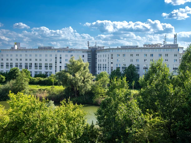 Best Western Mörfelden - Hotel complex Large, white hotel complex in a green setting by the water.