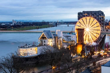 Kölner Hafenweihnachtsmarkt am Schokoladenmuseum Blick auf den hell erleuchteten Weihnachtsmarkt am Schokoladenmuseum Köln, mit dem Rhein im Hintergrund.