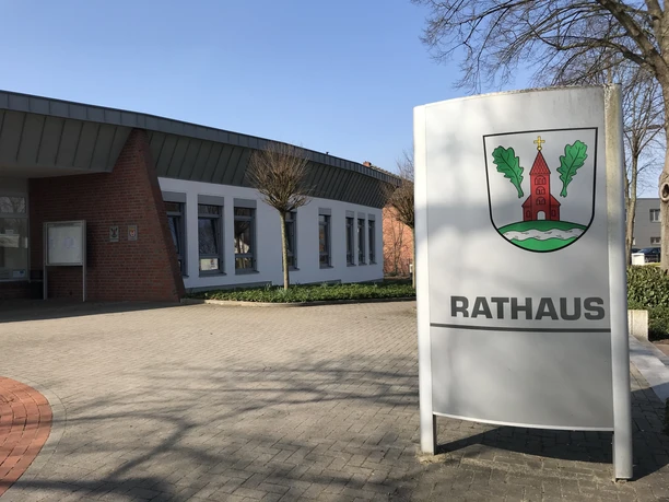 Grasberger Rathaus Modernes Rathausgebäude in Grasberg mit Backsteinfassade, großen Fenstern und Gemeindewappen.