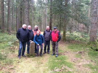 Wandergruppe an einem Grenzstein aus dem Jahr 1606