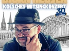 Björn Heuser vor der Kölner Dom-Silhouette und Hohenzollernbrücke.