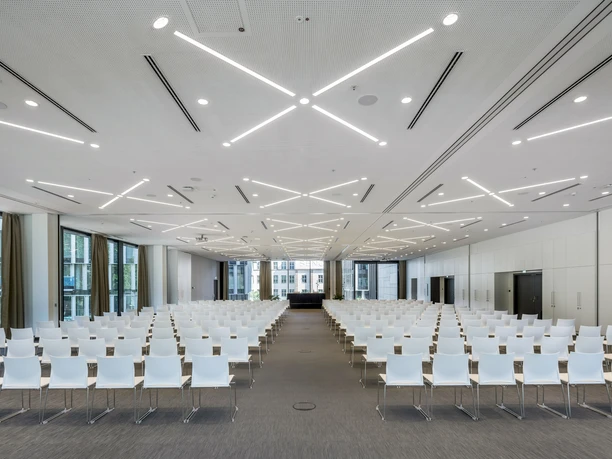 Melia Frankfurt City - Moderner Saal Moderner Saal mit weißen Stuhlreihen.