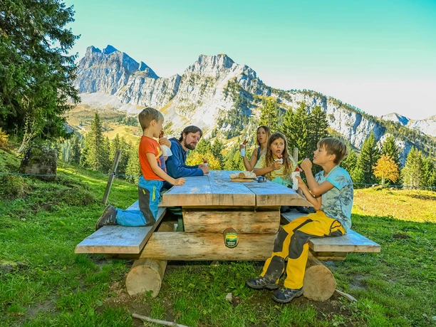Coin à griller GrimmiJutz au poste 4 Une famille est assise à une table en bois et mange