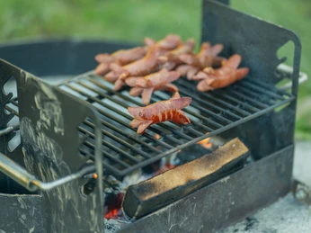 Barbecue moderne près de la rôtisserie GrimmiJutz poste 4 Schön gebratene Cervelatwürste liegen auf dem GrillrostBeautifully roasted Cervelat sausages on the grill rackDes cervelas bien grillés sont posés sur la grille du barbecue
