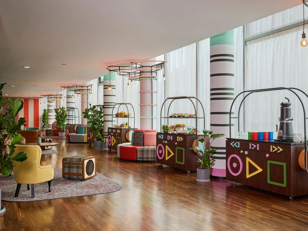 AVANI Frankfurt City - Lobby Farbenfrohe Lobby mit Buffet-Stationen und Retro-Design.