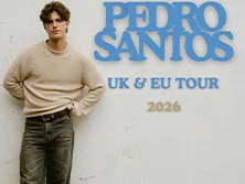 Pedro Santos steht lässig vor einer Wand mit Tourdaten für UK und EU im Jahr 2026.