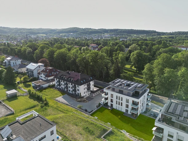 Parkblick, Haus am Kurpark, Ferienwohnung Moderne Ferienhäuser am Kurpark mit Blick auf Grünflächen und bewaldete Hügel im Hintergrund.