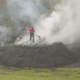 Der Köhler Reinhold Wagner kontrolliert die Rauchöffnung am Meiler. So stellt er sicher, dass das Holz bei ca. 300 °C verkohlt und nicht höhere Temperaturen eintreten, bei denen das Holz verbrennen würde.