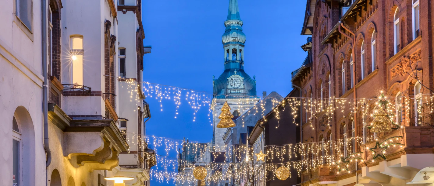 Straße mit Lichterketten und goldenen Kugeln. Im Hintergrund eine große Kirche.