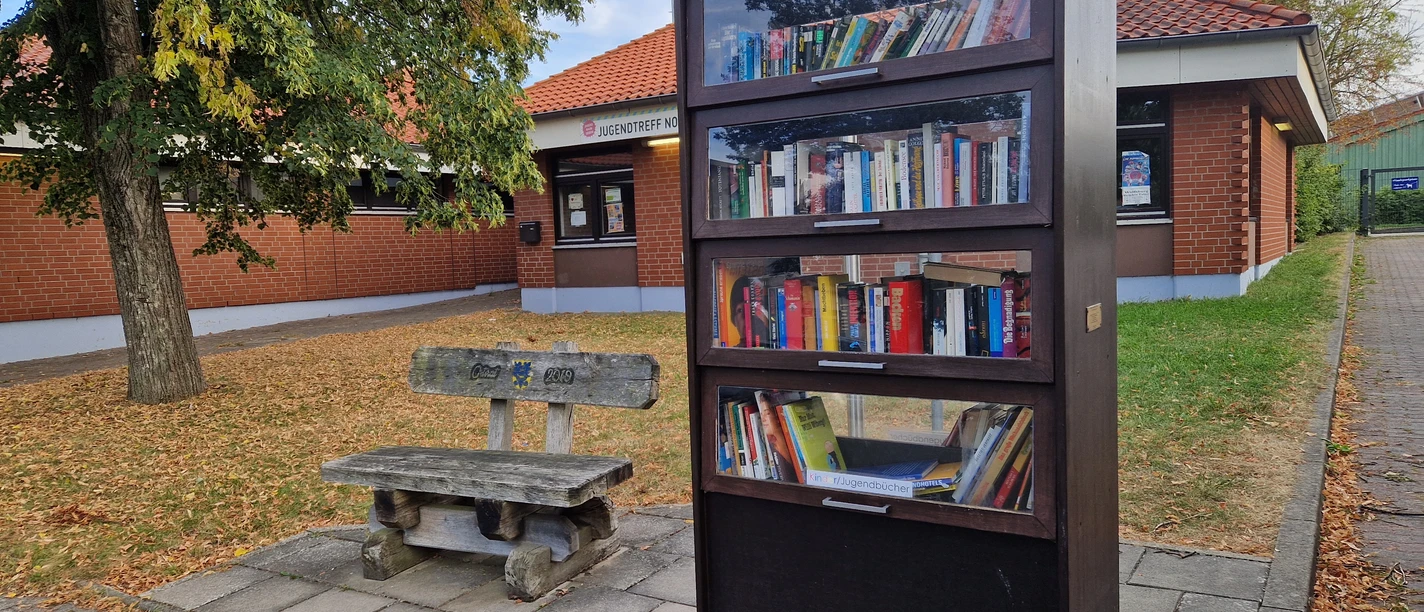 Buecherschrank.jpg Gut gefüllter Bücherschrank neben einer Sitzbank