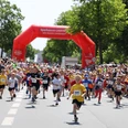 Stadtlauf_3626-os A 1366.jpg Children start the city run under a red archway, surrounded by rows of cheering spectators.