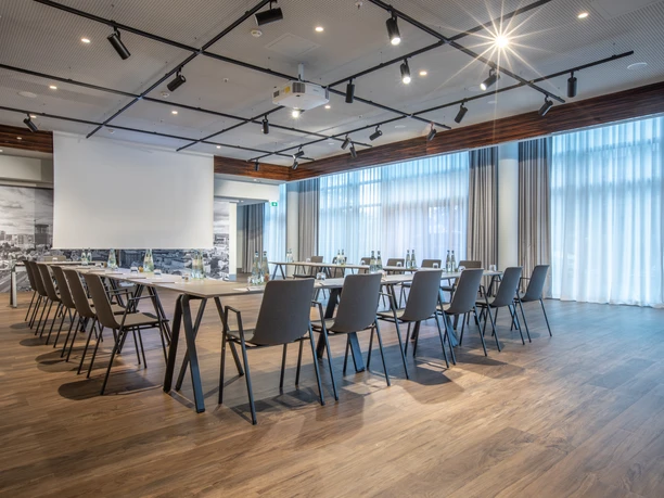 Radisson Blu Hotel, Frankfurt - Tagungsraum Tagungsraum mit U-Tafel, Leinwand und Holzboden.