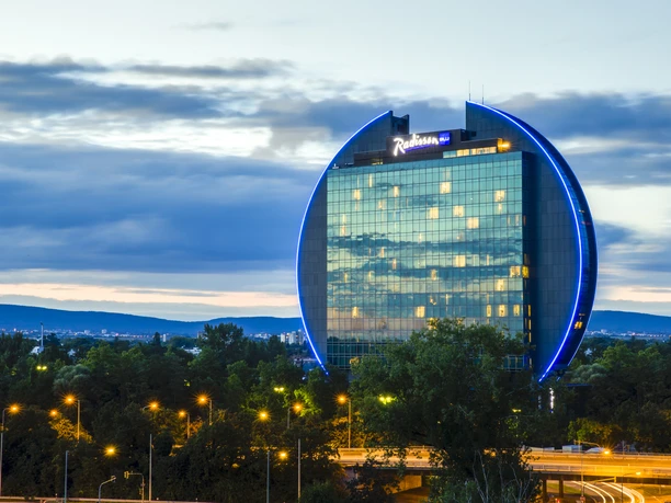 Radisson Blu Hotel, Frankfurt - Hotel building Round hotel building with blue lighting.