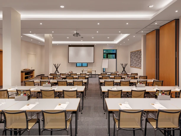 Holiday Inn Frankfurt - Alte Oper - Tagungsraum Tagungsraum mit Tischreihen und Leinwand.
