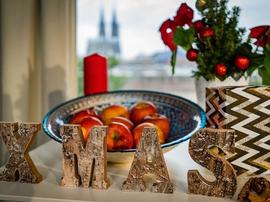 _DSC3649 Kopie.jpeg Weihnachtliche Deko mit Äpfeln und Kerze vor Kölner Domhintergrund.Christmas decoration with apples and candle in front of Cologne Cathedral background.