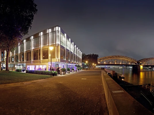 the view Cologne Panoramablick auf das nächtliche Köln am Rhein mit beleuchteter Hohenzollernbrücke und Kölner Dom.Panoramic view of Cologne at night on the Rhine with illuminated Hohenzollern Bridge and Cologne Cathedral.