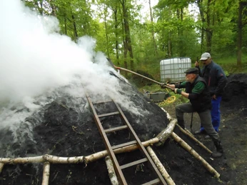 Anzünden des Holzkohlenmeilers