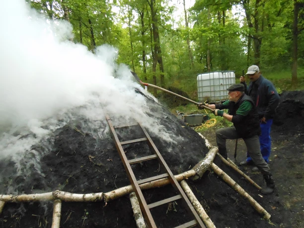 Anzünden des Holzkohlenmeilers