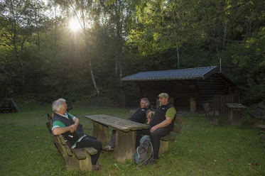 Schutzhütte und Bänke mit Wanderern