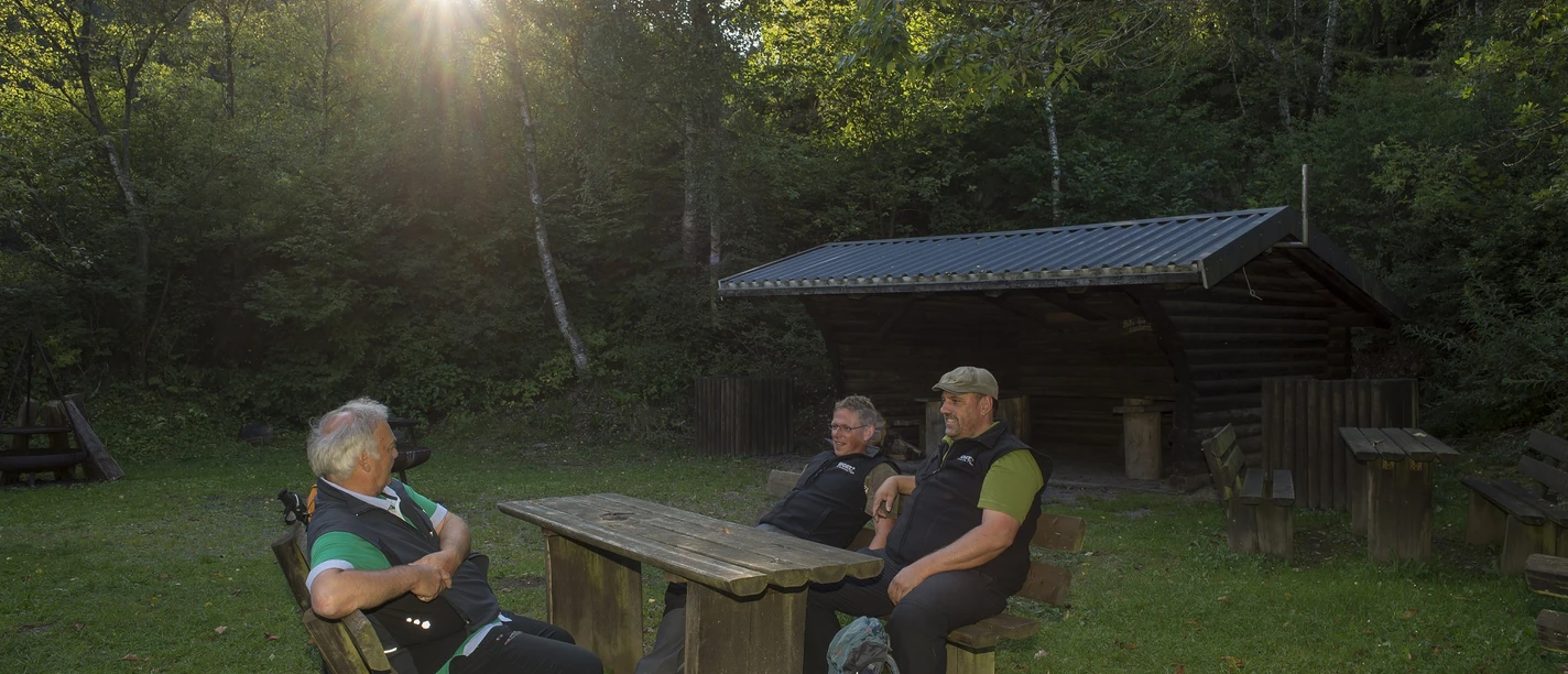 Schutzhütte und Bänke mit Wanderern