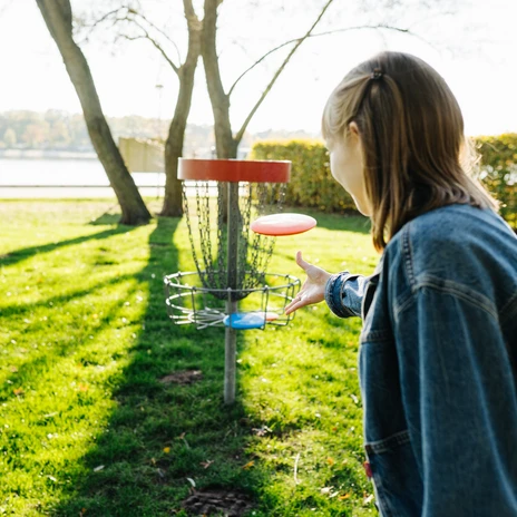 Discgolfspielerin.jpg Frau spielt am Allersee Discgolf.
