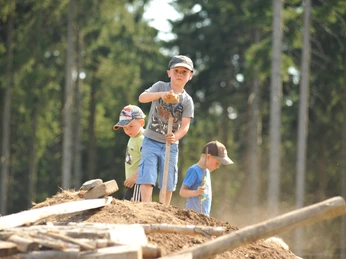 Kinder auf Erdhügel