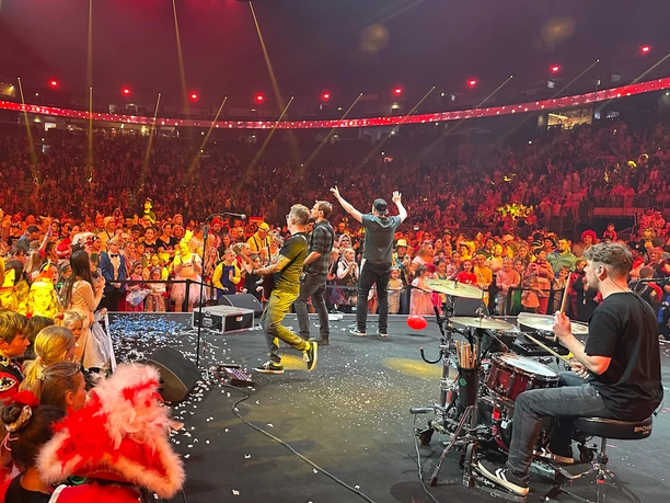 Lachende PÄNZarena A cheerful carnival event in the LANXESS arena with a colorful crowd and musical performance.