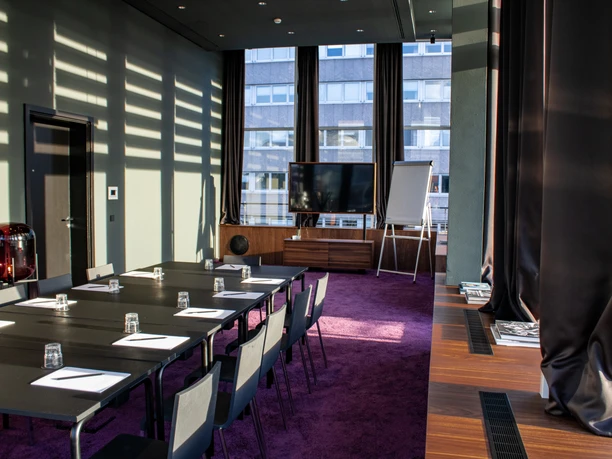 Roomers Frankfurt Central, Autograph Collection - Besprechungsraum Besprechungsraum mit violettem Teppich und Fensterfront.