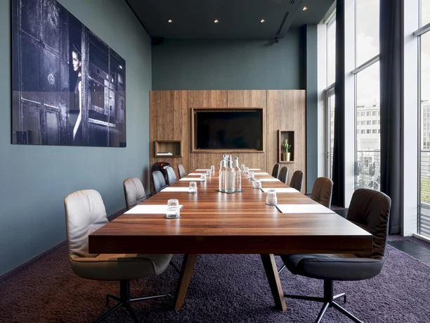 Roomers Frankfurt Central, Autograph Collection - Conference room Elegant conference room with long wooden table.